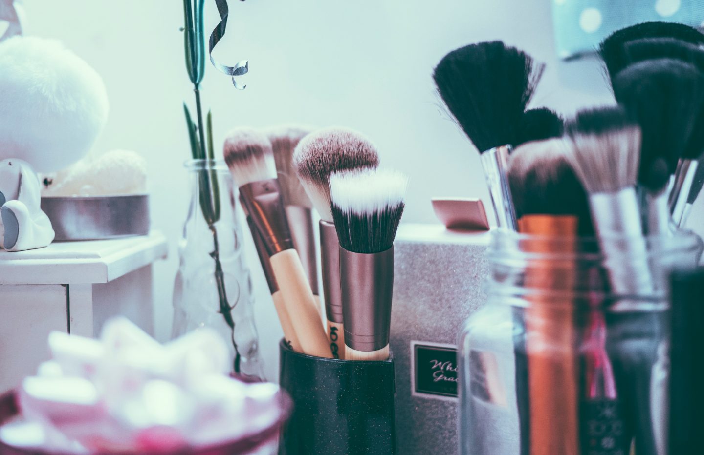 Makeup brushes, makeup foundation, skincare creams organized on a table