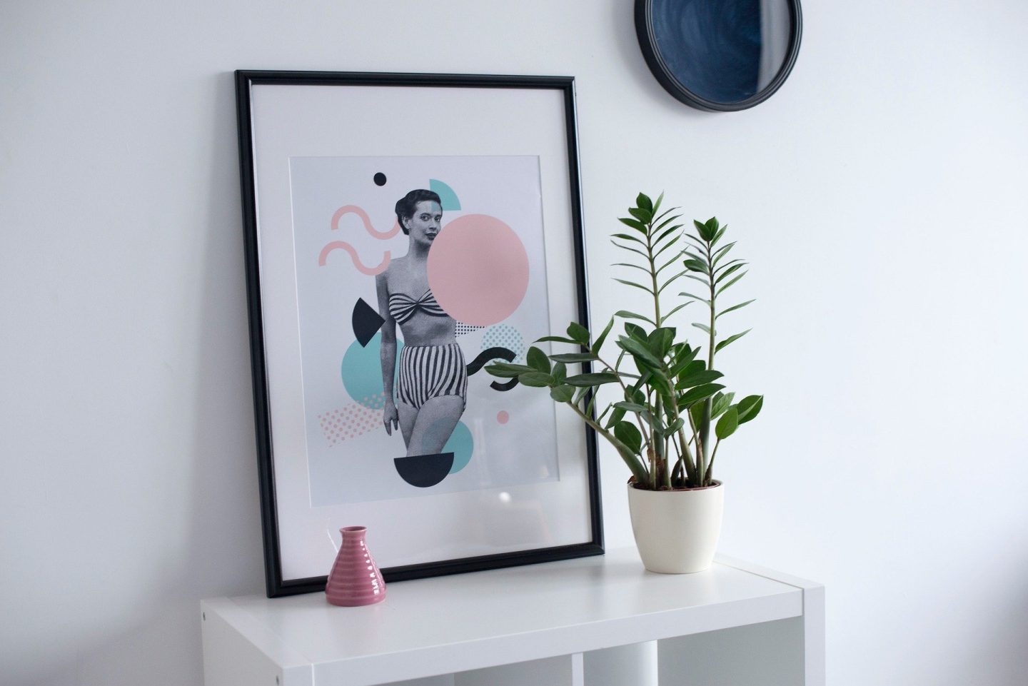 picture frame and green plant on a white table