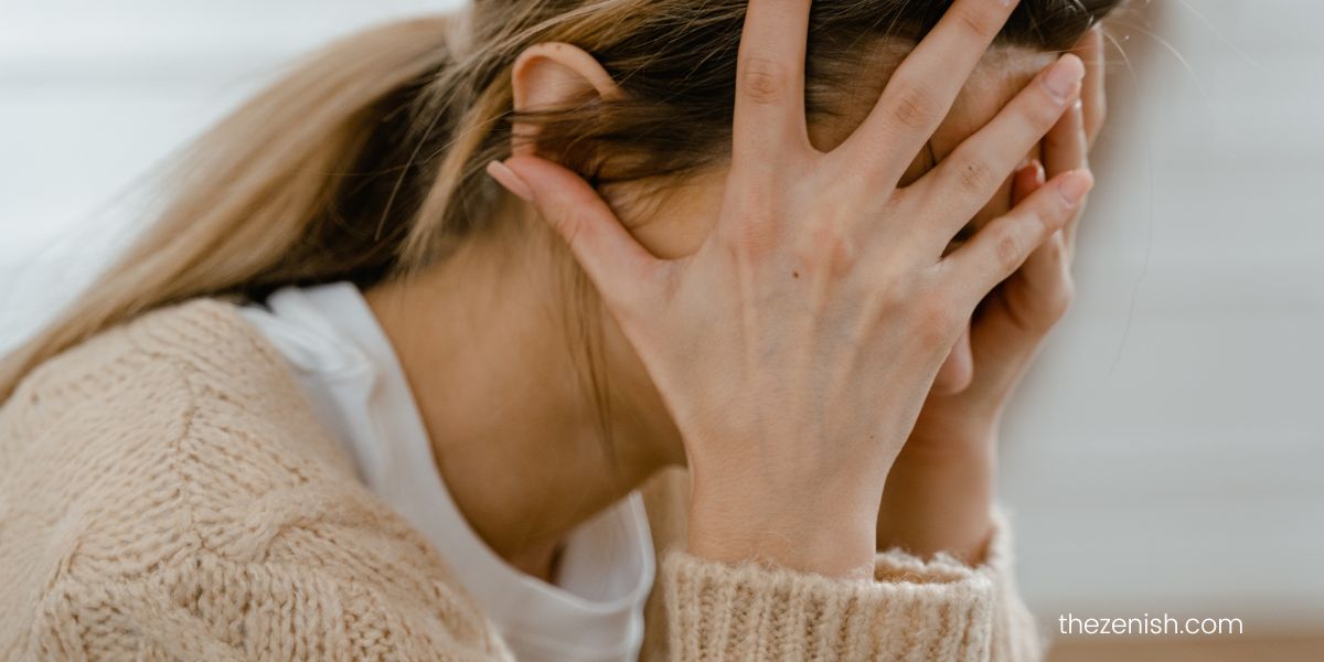 Woman looking disheveled with her hands covering her face 